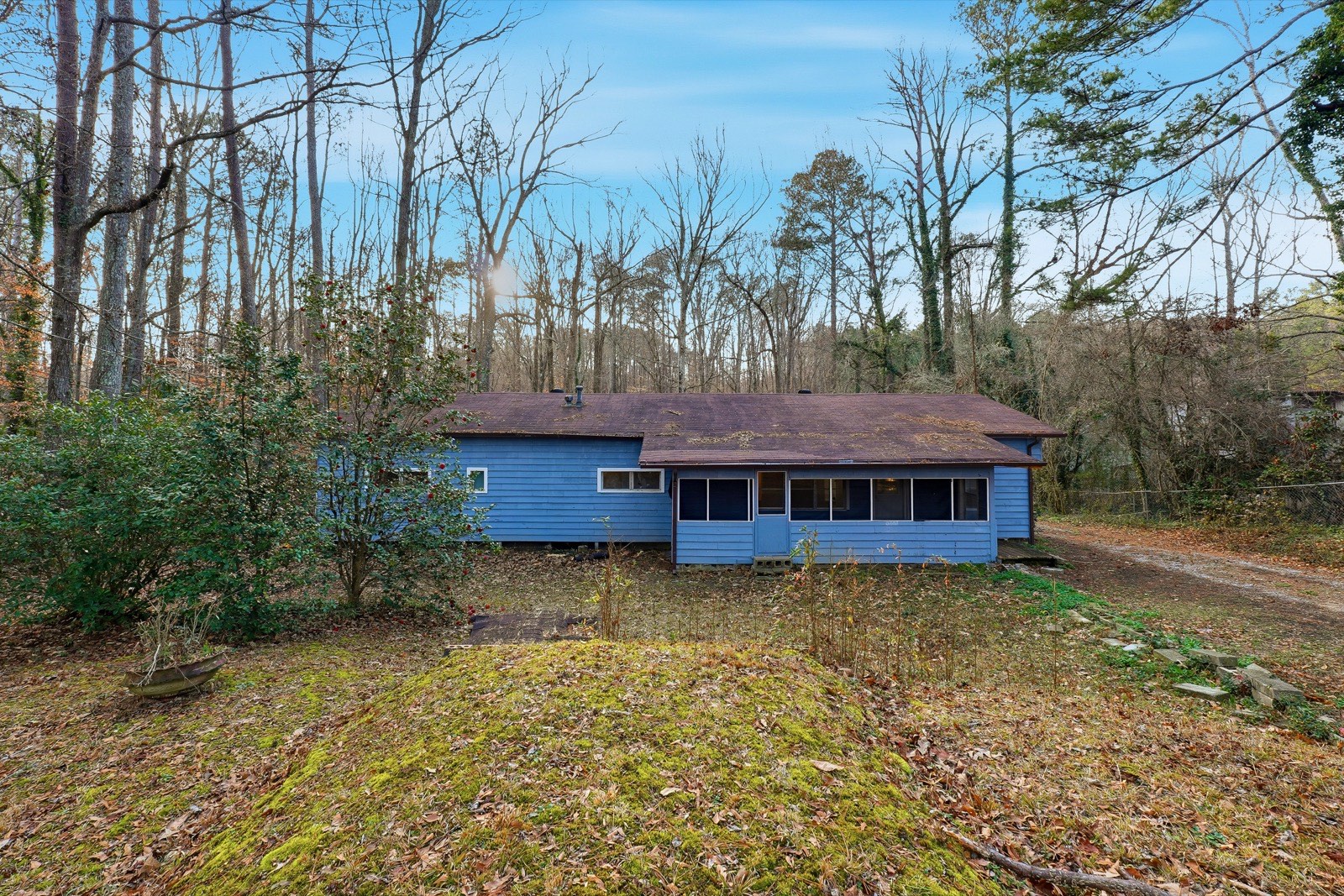 Renovated ranch exterior after renovation with fresh blue siding, clean landscaping, and restored curb appeal